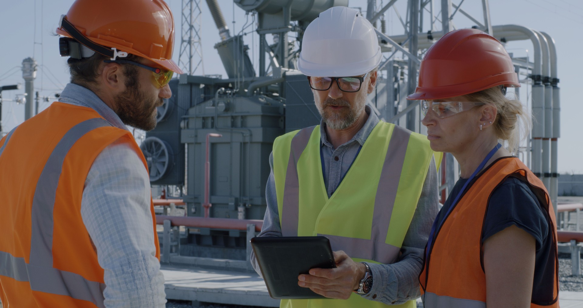 Female engineer discussing data on tablet with men